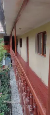 a balcony of a house with a red railing at Hospedaje La Ñusta in Ollantaytambo