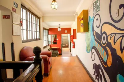 a hallway with a living room with a painting on the wall at Bear Packer Hostel in Cusco