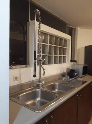 a kitchen with a stainless steel sink and a window at Amplio, cómodo y moderno apartamento cerca al Mall in Lima