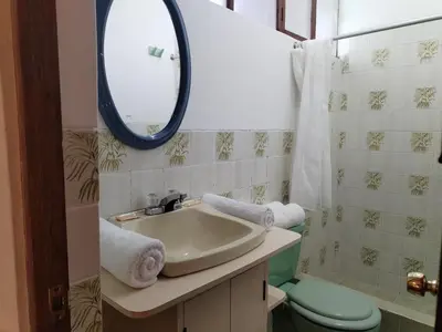 a bathroom with a sink and a toilet and a mirror at El Jardín de Jeni in Cusco