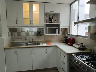 a kitchen with white cabinets and a sink at Runawasi Apartments - Amaru 3BDR in Lima