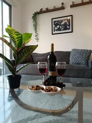 a table with two glasses of wine and a plate of food at Runawasi Apartments - Amaru 3BDR in Lima