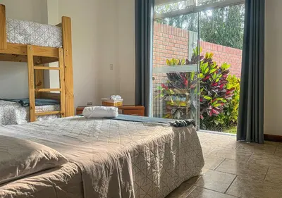 a bedroom with a bed and a large window at KUSI WASI CIENEGUILLA in Cieneguilla