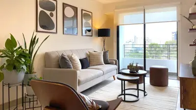 a living room with a couch and a large window at The Classic by Wynwood House in Lima