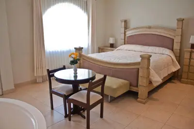 a bedroom with a bed and a table and chairs at Lunahuana River Resort in Lunahuaná