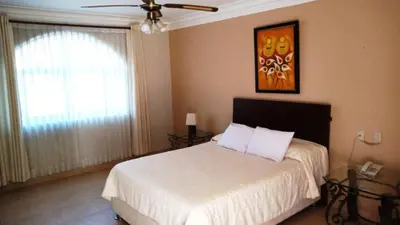 a bedroom with a bed and a ceiling fan at Lunahuana River Resort in Lunahuaná