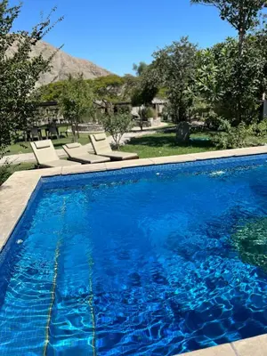 a swimming pool with two lounge chairs next to it at Refugio de Santiago Ecolodge in Lunahuaná