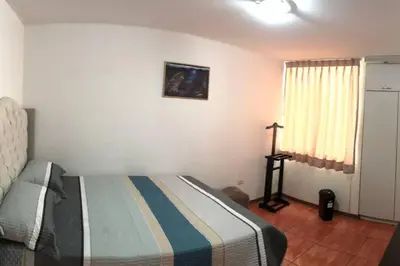 a bedroom with a bed and a cross on the wall at Hermoso Duplex en Chorrillos in Lima
