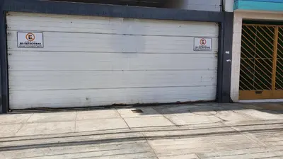 a garage door with two no parking signs on it at Hermoso departamento amoblado con piscina, area parrillas in Lima