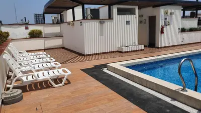 a deck with chairs and a swimming pool at Hermoso departamento amoblado con piscina, area parrillas in Lima