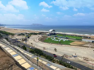a road with cars on it next to the ocean at Cómodo, céntrico, cerca a Parque Media Luna in Lima