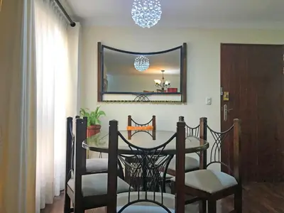 a dining room with a table and chairs and a mirror at Cómodo, céntrico, cerca a Parque Media Luna in Lima