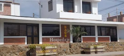 a building with windows and a stone wall at R. A. C. S. in Paracas