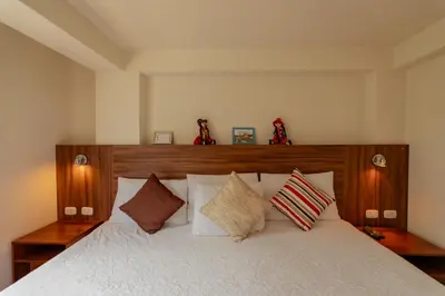a bedroom with a large white bed with pillows at Dreams Boutique Hotel Cusco in Cusco