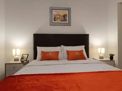 a bedroom with a large bed with two orange pillows at Runawasi Apartments - Killary Miraflores 2BDR in Lima