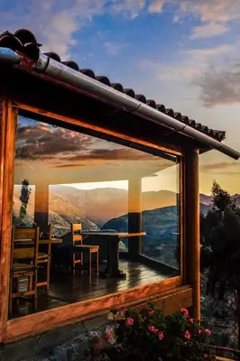 a reflection of a table and chairs in a window at Refugio Viñak in Viñak