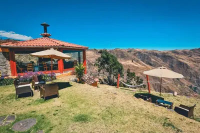 a gazebo with chairs and umbrellas on a hill at Refugio Viñak in Viñak