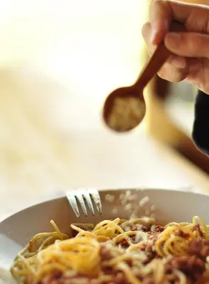 a person holding a fork over a plate of pasta at Refugio Viñak in Viñak