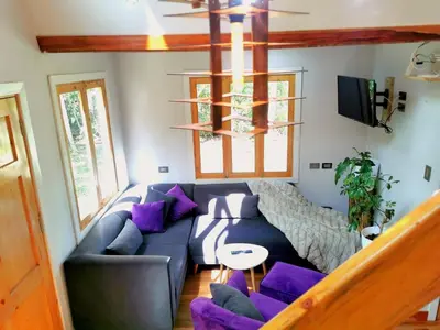 a living room with a blue couch and purple pillows at La casa del Erizo in Oxapampa