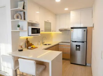 a kitchen with white cabinets and a stainless steel refrigerator at Bright 1BR close to boulevard in Lima