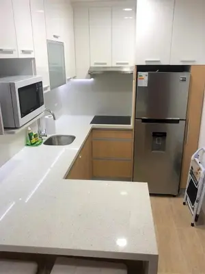 a kitchen with white cabinets and a stainless steel refrigerator at Bright 1BR close to boulevard in Lima