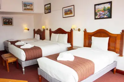 a hotel room with two beds in a room at Hotel Amerinka in Cusco