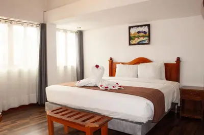 a hotel room with a large bed with a flower on it at Hotel Amerinka in Cusco