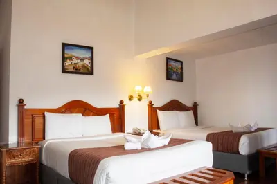 a hotel room with two beds in a room at Hotel Amerinka in Cusco