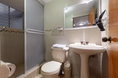 a bathroom with a toilet and a sink and a shower at Hotel Amerinka in Cusco