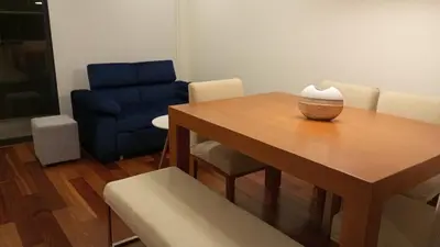 a living room with a table and a blue chair at EL PRAT Luxury Aparment Lima Peru in Lima