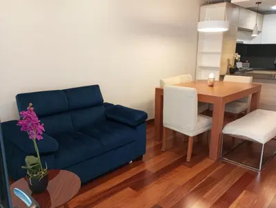 a living room with a blue couch and a table at EL PRAT Luxury Aparment Lima Peru in Lima