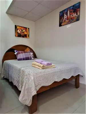 a bedroom with a bed with a wooden head board at Carlos Guest House 2 Cusco in Cusco