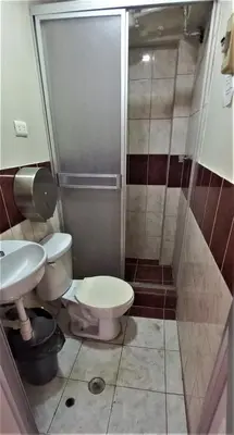 a small bathroom with a toilet and a shower at Carlos Guest House 2 Cusco in Cusco