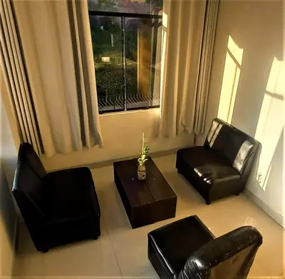 a living room with two chairs and a table and a window at Carlos Guest House 1 Cusco in Cusco