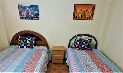 two beds sitting next to each other in a bedroom at Carlos Guest House 1 Cusco in Cusco