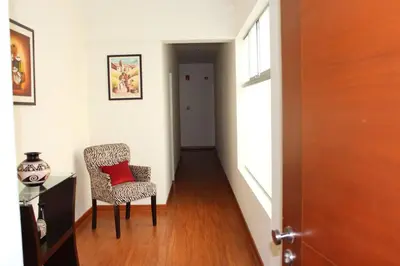 a hallway with a chair with a red pillow on it at New and nice apartment Miraflores in Lima