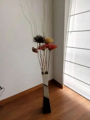 a vase with flowers in the corner of a room at New and nice apartment Miraflores in Lima