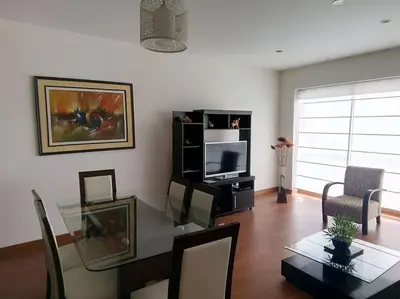 a living room with a table and a television at New and nice apartment Miraflores in Lima
