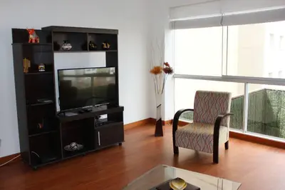 a living room with a television and a chair at New and nice apartment Miraflores in Lima
