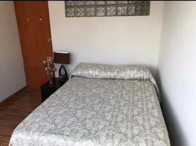 a bedroom with a bed with a gray comforter at Departamento en el centro histórico en 3er y 4to piso in Ayacucho