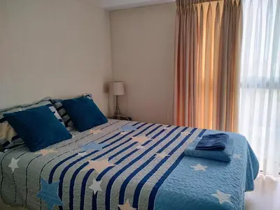 a bedroom with a blue and white bed with blue pillows at Confortable habitación baño privado desayuno opcional in Lima