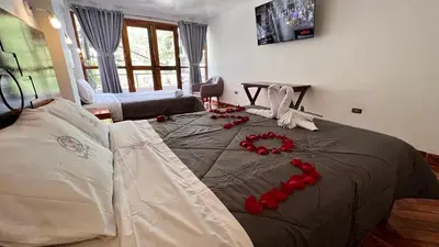 a bed with red decorations on top of it at QUECHUA´S HOUSE Hostal & Coffee in Machu Picchu