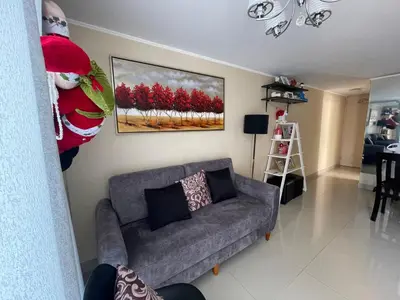 a living room with a gray couch and a painting of red trees at Lindo y Acogedor Departamento en Lima! in Lima