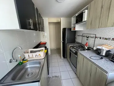 a small kitchen with a sink and a refrigerator at Lindo y Acogedor Departamento en Lima! in Lima