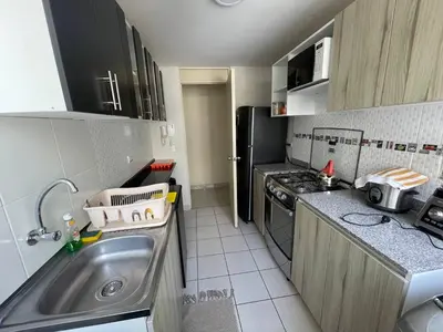 a small kitchen with a sink and a refrigerator at Lindo y Acogedor Departamento en Lima! in Lima