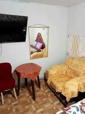 a room with two beds and a table and a mirror at Posada Ternura in Lima