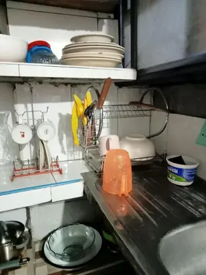 a kitchen counter with a sink and dishes on a shelf at Posada Ternura in Lima