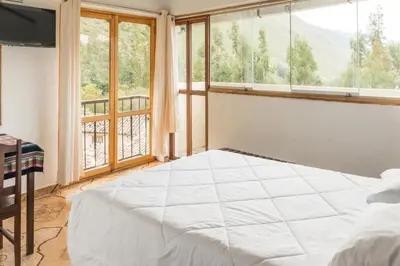 a bedroom with a bed and a large window at Sueños del Valle Sagrado in Urubamba