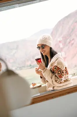 a woman sitting at a table looking at her cell phone at Sueños del Valle Sagrado in Urubamba