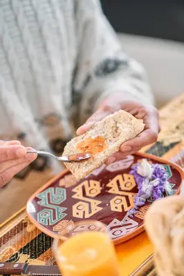 a person is eating a sandwich on a plate at Sueños del Valle Sagrado in Urubamba